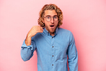 Young caucasian man isolated on pink background laughing about something, covering mouth with hands.
