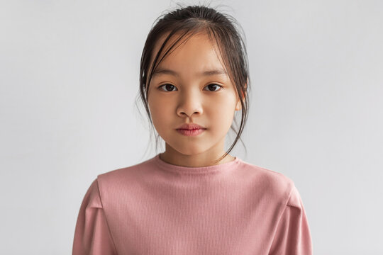 Portrait Of Serious Asian Girl Looking At Camera, Gray Background