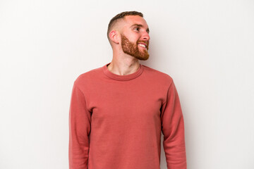 Fototapeta premium Young caucasian man isolated on white background relaxed and happy laughing, neck stretched showing teeth.