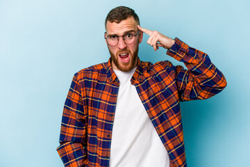 Young caucasian man isolated on blue background showing a disappointment gesture with forefinger.