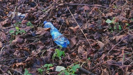 Blue PET Plastic Water Bottle Garbage Dumped on Park Lawn Littering City Public Space