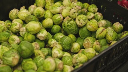 Plastic Crate Box Of Fresh Brussels Sprouts in Grocery Store Vegetables Stand	
