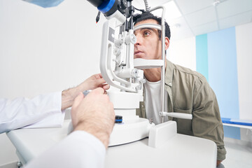 Ophthalmologist using medical equipment, appointment at the hospital