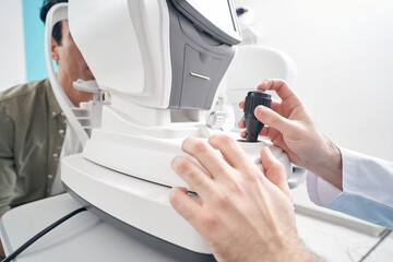 Adult doctor working at the refraction machine