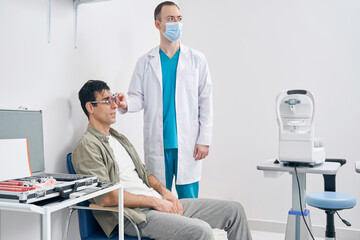 Ophthalmologist diagnosing vision of man at the hospital