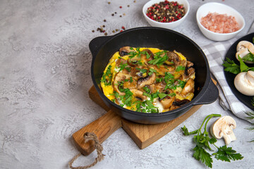 Omelette with champignons and herbs in a frying pan, top view with copy space.