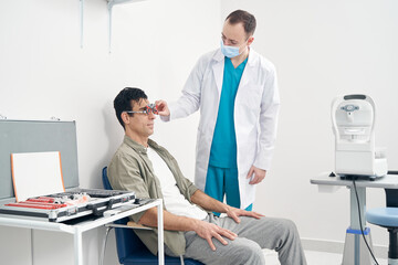 Obraz premium Doctor diagnosing vision of man at the hospital