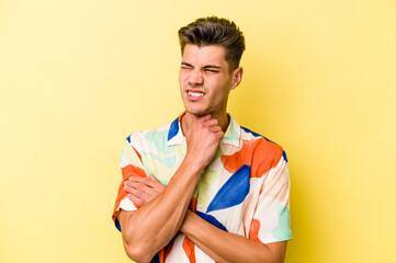 Young caucasian man isolated on yellow background suffers pain in throat due a virus or infection.