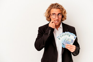 Young caucasian business man holding banknotes isolated on white background relaxed thinking about something looking at a copy space.