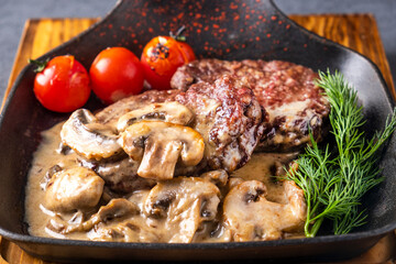 Fried meat with mushrooms and sauce. Closeup