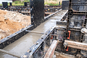 Plastic formwork with metal reinforcement for pouring concrete a solid foundation for a house. Building concept.