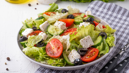 Salad with cherry tomatoes, cucumber, lettuce and cheese. Healthy food concept. Closeup