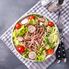 Delicious beef tongue salad served with fork and knife. Top view