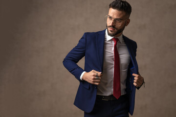 handsome businessman opening his suit, wearing eyeglasses