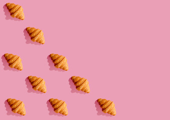 croissant print on pink background with black shadow with copy space