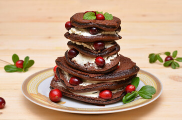 chocolate pancakes with cranberries on a plate