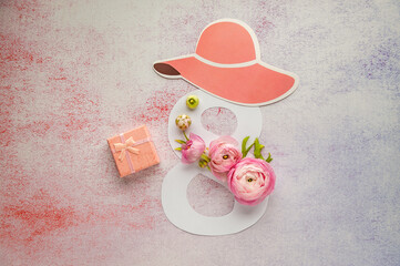 International Women's Day. Banner, flyer, beautiful postcard for March 8. Hat and pink ranunculus decorates the number eight on pastel background. Soft focus. Top view.