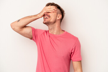 Young caucasian man isolated on white background covering ears with hands trying not to hear too loud sound.