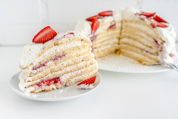 Delicious cake with cream cheese and strawberries. Beautiful serving on a white brick background