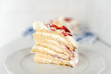 Delicious cake with cream cheese and strawberries. Beautiful serving on a white brick background