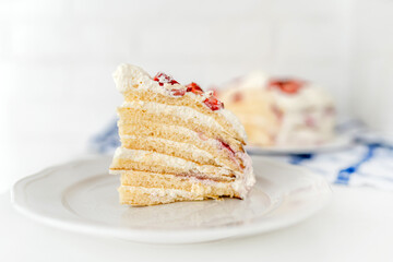 Delicious cake with cream cheese and strawberries. Beautiful serving on a white brick background