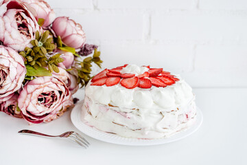 Cake with strawberries and mascarpone on a white wall background. Delicious dessert