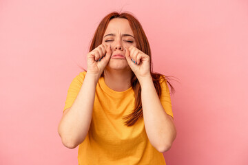 Young caucasian woman isolated on pink background whining and crying disconsolately.