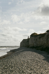 stone beach cliff birds sky Denmark