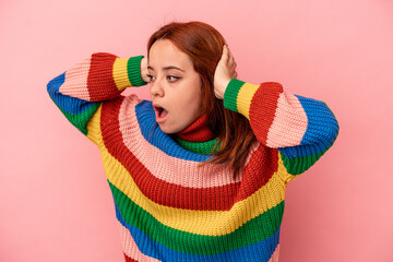 Young caucasian woman isolated on pink background screaming, very excited, passionate, satisfied with something.