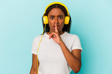 Young African American woman listening to music isolated on blue background  keeping a secret or asking for silence.