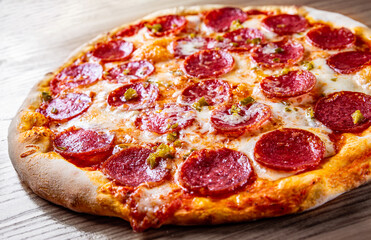 Hot Pepperoni Pizza with Mozzarella cheese, salami, Tomato sauce, pepper, Spices. Italian pizza on wooden background