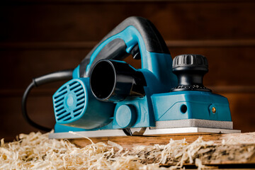 Manual electric plane on an untreated log of a tree. Wooden products. Production of wood products.