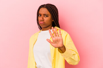 Young african american woman isolated on pink background  rejecting someone showing a gesture of disgust.