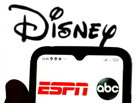 In this photo illustration, the ESPN on ABC logo is displayed on a smartphone screen with the Dysney logo in the background.