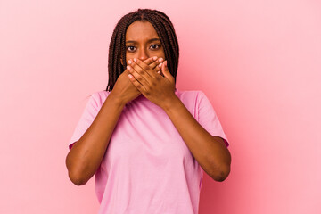 Young african american woman isolated on pink background  covering mouth with hands looking worried.