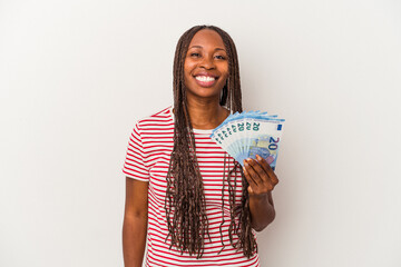 Young african american woman holding banknotes isolated on white background happy, smiling and cheerful.