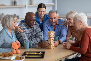 Cheerful senior people paying jenga at nursing home