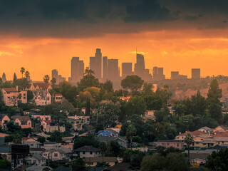 City of Los Angeles downtown skyline at sunset, residential neighborhood buildings on hills in...