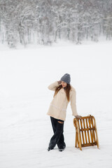 Young woman on a winter walk with a sled. Winter outdoor activities