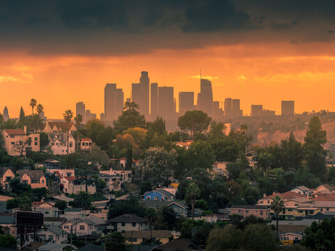 City of Los Angeles downtown skyline at sunset, residential neighborhood buildings on hills in foreground