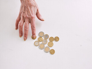 senior hands counting euro coins on the table. poverty, crisis, deposit, recession concept 