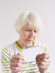 senior sad woman looking at herself in mirror. Age, time, skin care concept