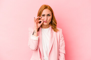 Young caucasian woman isolated on pink background with fingers on lips keeping a secret.