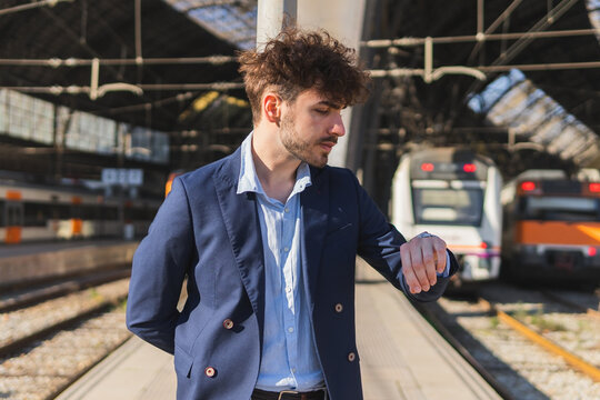 Hispanic man checking time on railroad station