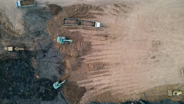 Aerial top view with drone Excavators and dumpers work at large construction sites.