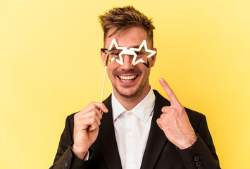 Young caucasian man celebrating new year isolated on yellow background