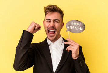 Young caucasian man celebrating new year isolated on yellow background