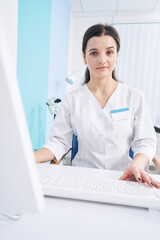 Tranquil young doctor sitting at work in her office