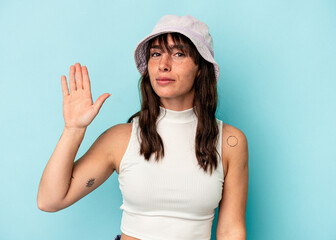 Young Argentinian woman isolated on blue background smiling cheerful showing number five with fingers.