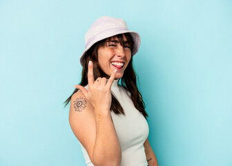 Naklejka premium Young Argentinian woman isolated on blue background showing rock gesture with fingers